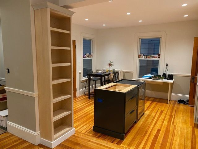 A room with hardwood floors and shelves and a desk