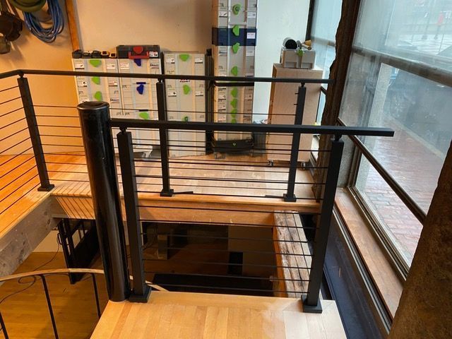 A staircase with a black railing and a wooden floor.