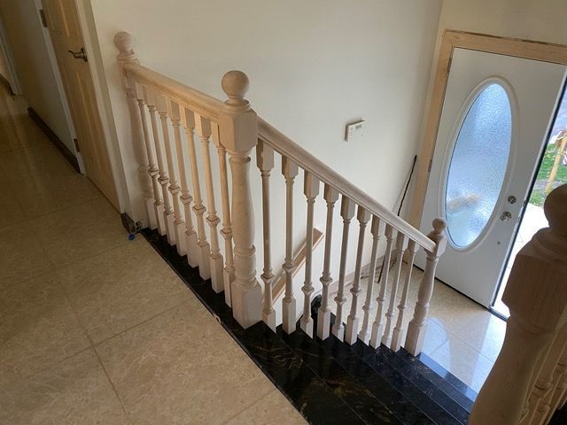 A staircase with a wooden railing leading up to a door.