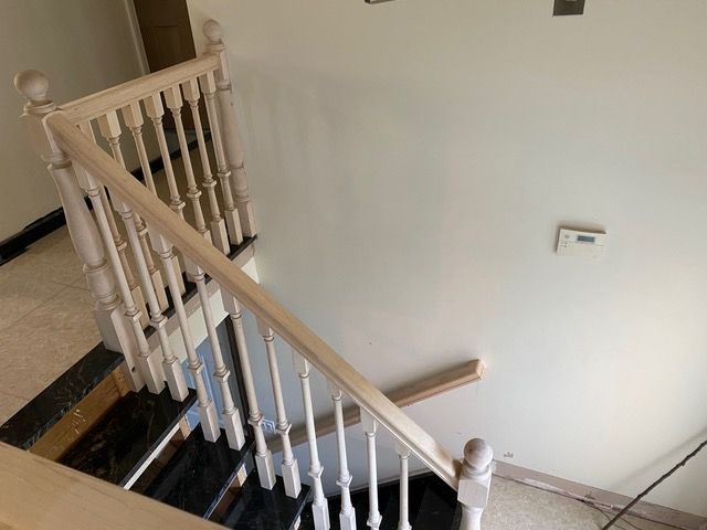 A staircase with a white railing and black steps in a room.