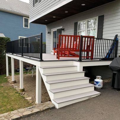 There is a deck with stairs leading up to it and a bench on it.