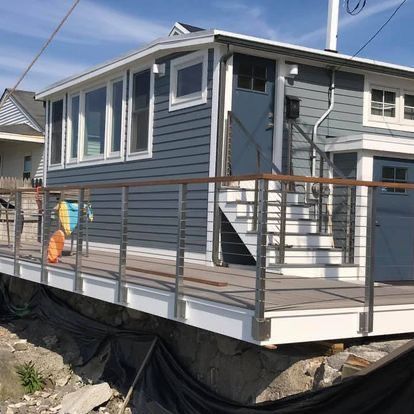 A house with a balcony and stairs on the side of it.