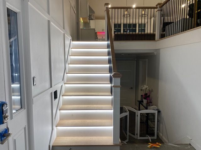 A staircase in a house with lights on the steps.