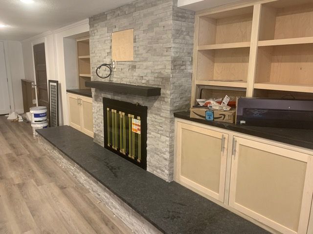 A living room with a fireplace and built in shelves.