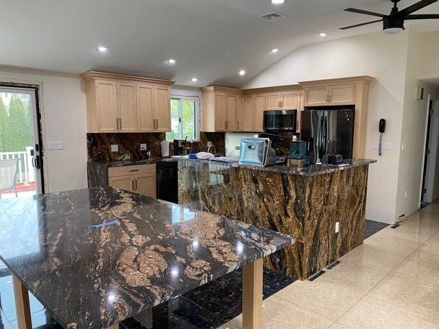 A kitchen with a large island and a ceiling fan.