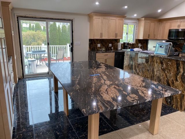 A kitchen with a large granite counter top and sliding glass doors