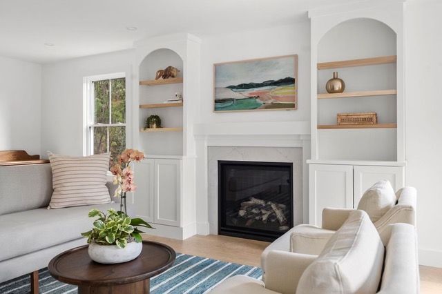 A living room with a couch , chair , table and fireplace.