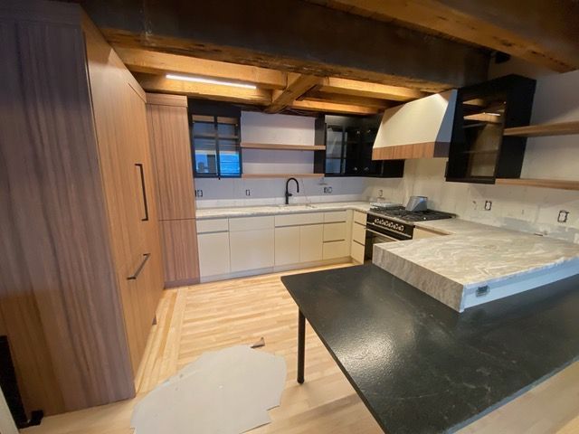A kitchen with wooden cabinets and a black counter top