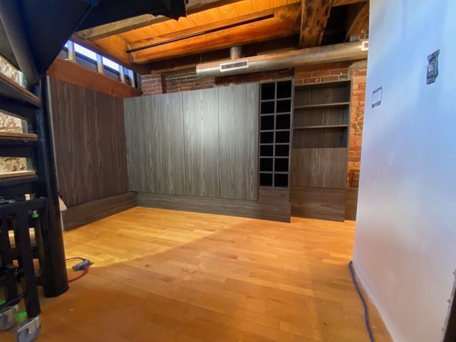 An empty room with wooden floors and a staircase.
