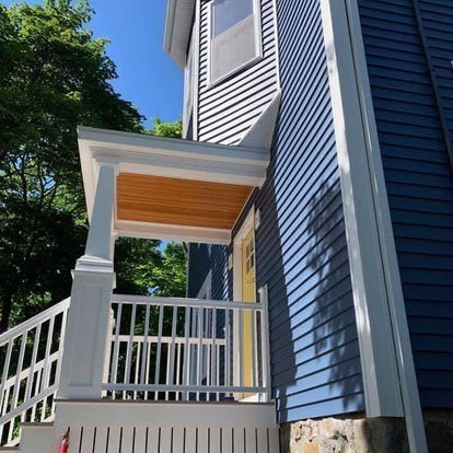 A blue and white house with a porch and stairs
