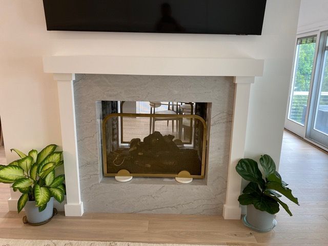 A fireplace in a living room with a flat screen tv above it.