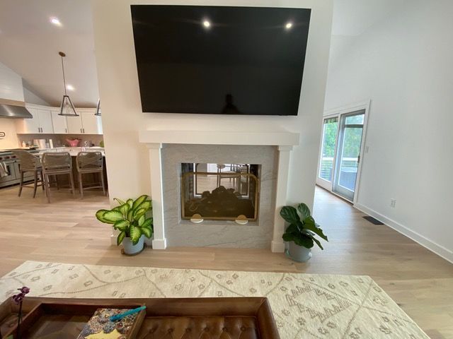A living room with a fireplace and a flat screen tv on the wall.