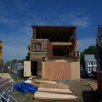 A house that is being remodeled with a blue tarp in front of it