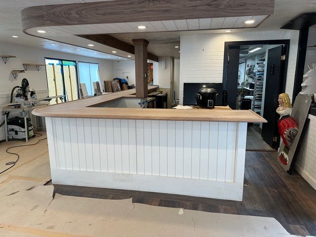 A kitchen counter with a wooden top is being built in a room.