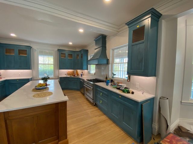 A kitchen with blue cabinets and white counter tops