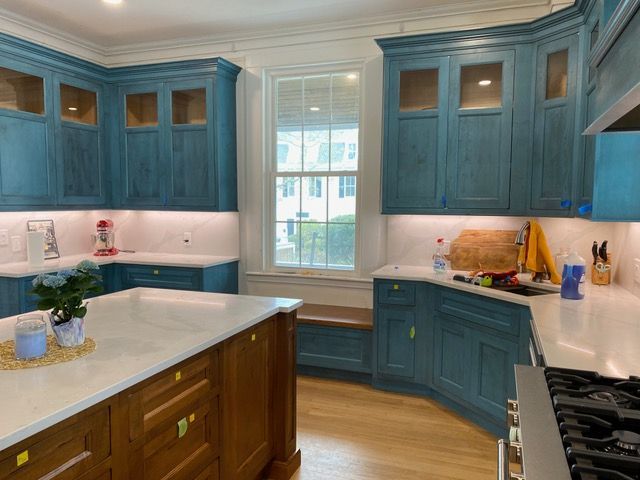 A kitchen with blue cabinets and white counter tops