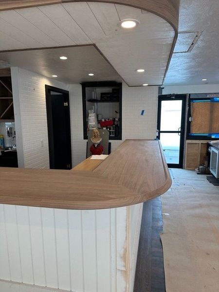 A kitchen with a wooden counter top and white cabinets