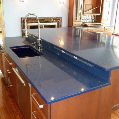 A kitchen with a blue counter top and a sink