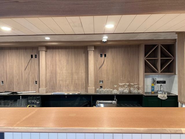 A kitchen with a copper counter top and wooden cabinets.