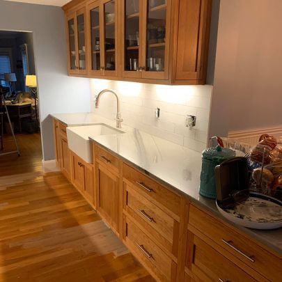 A kitchen with wooden cabinets , a sink , and a stainless steel counter top.