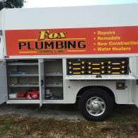 A white service truck with an orange panel labeled 