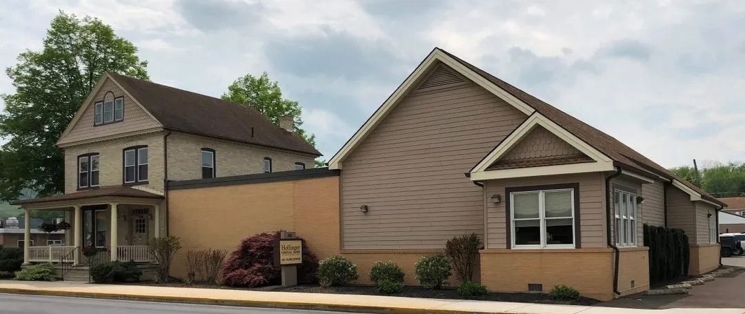 Buildings with varying rooflines. Beige brick exterior. Cloudy sky.