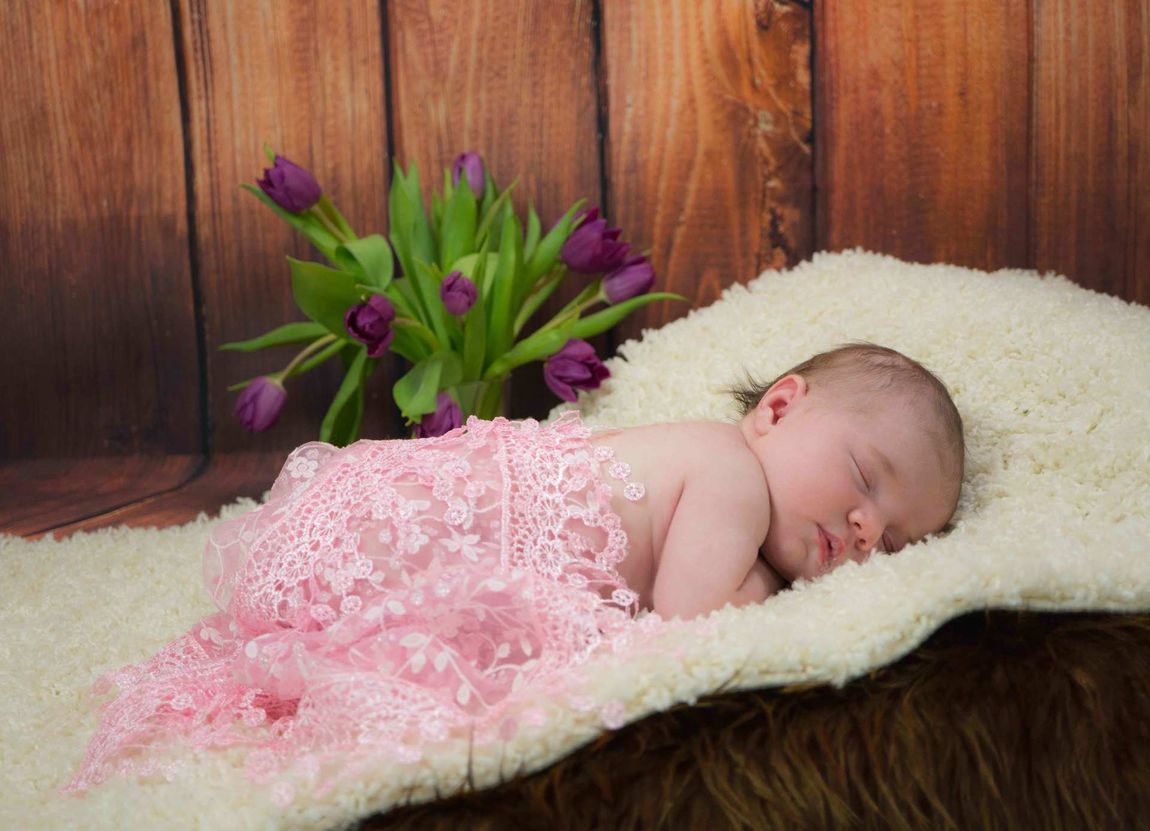 Newborn Neugeborenes Mädchen Baby rosa Holz Hintergrund Tulpe schlafen Augen zu nackig