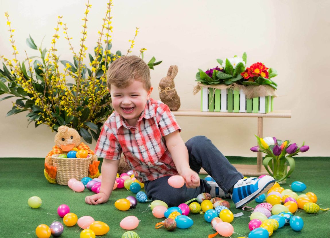 Kind Kleinkind Junge Ostern Eier lachen Hemd Turnschuhe Blumen Teppich Tulpen