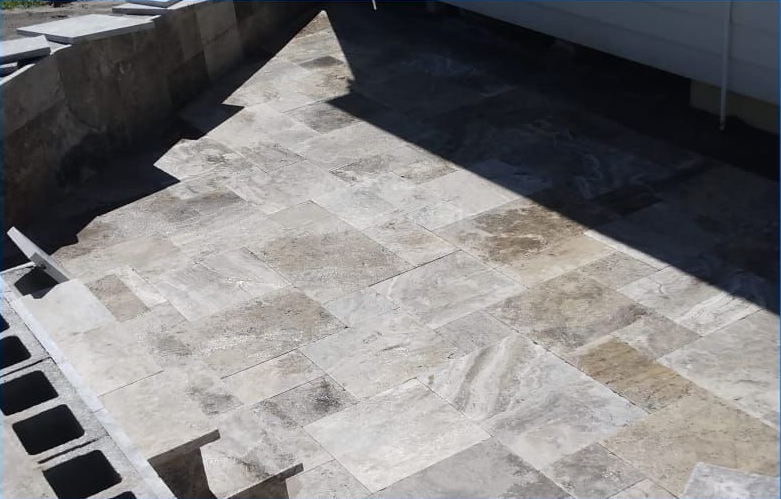 Stone tile patio with built-in steps and concrete block foundation.