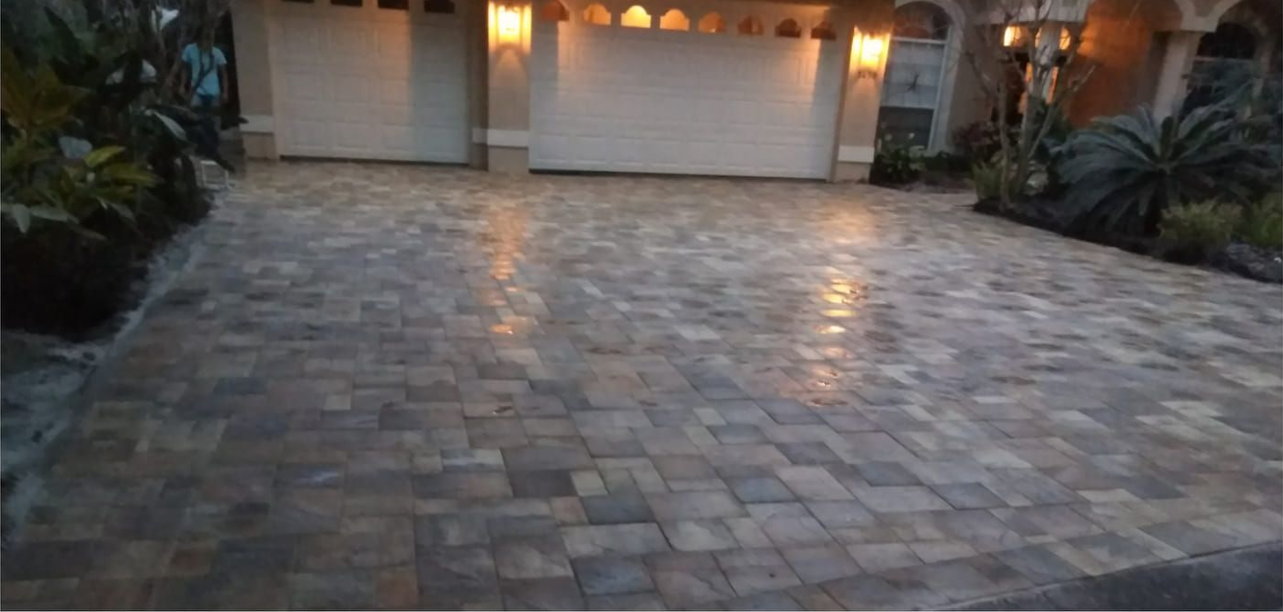 Pressure washer spraying water onto a brick patio, cleaning the surface.