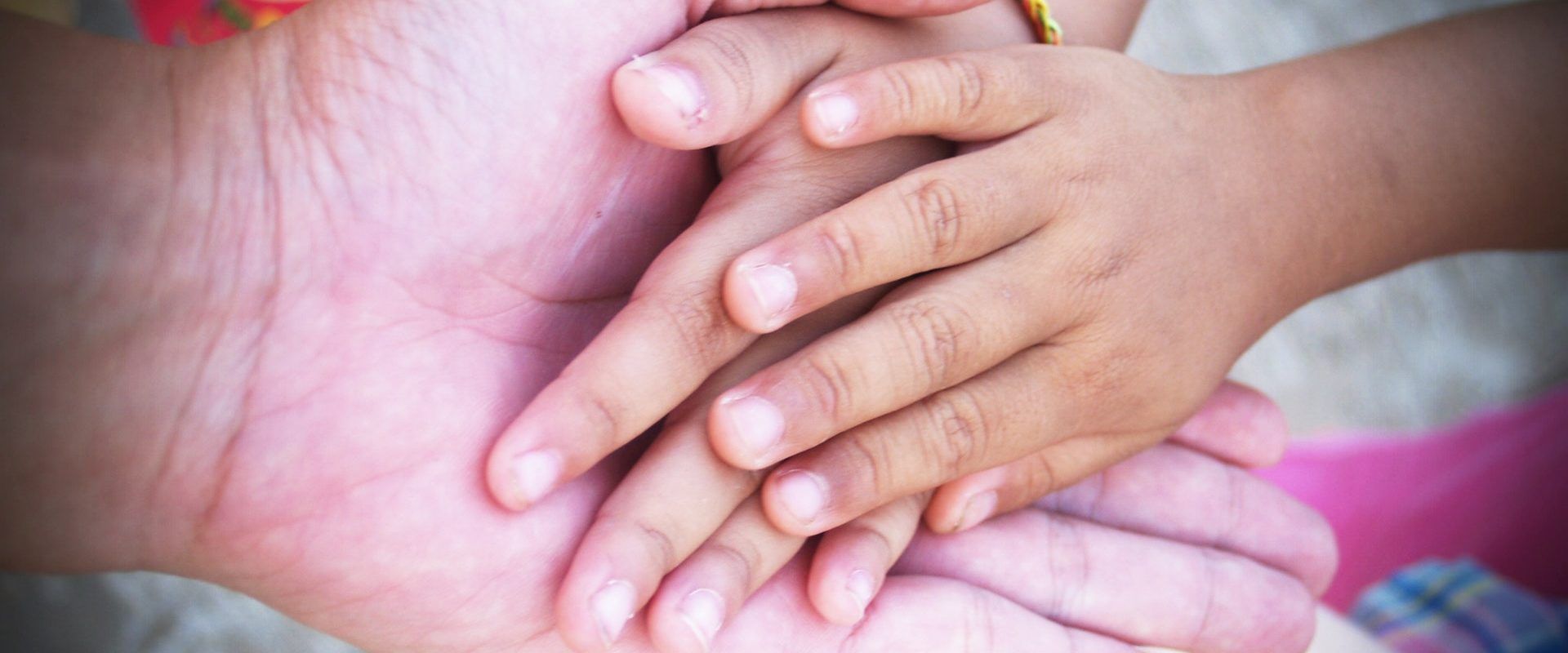 a close up of a person holding a child 's hand .