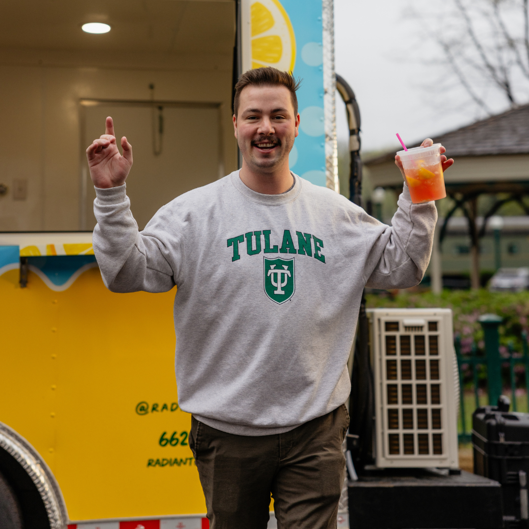 A person is holding a cup of iced tea with a straw.