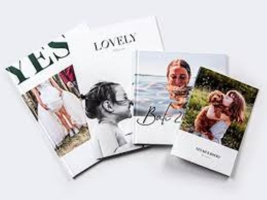 Tre libri sono appoggiati uno sopra l'altro su un tavolo.