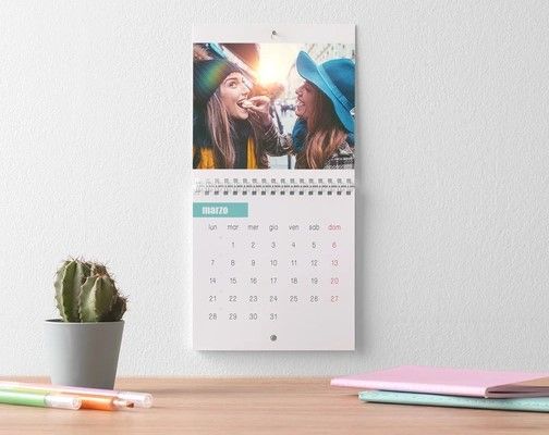 Un calendario è appeso a una parete accanto a un cactus.