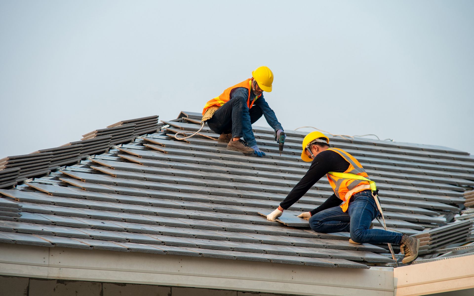 A construction worker is working on a metal roof.