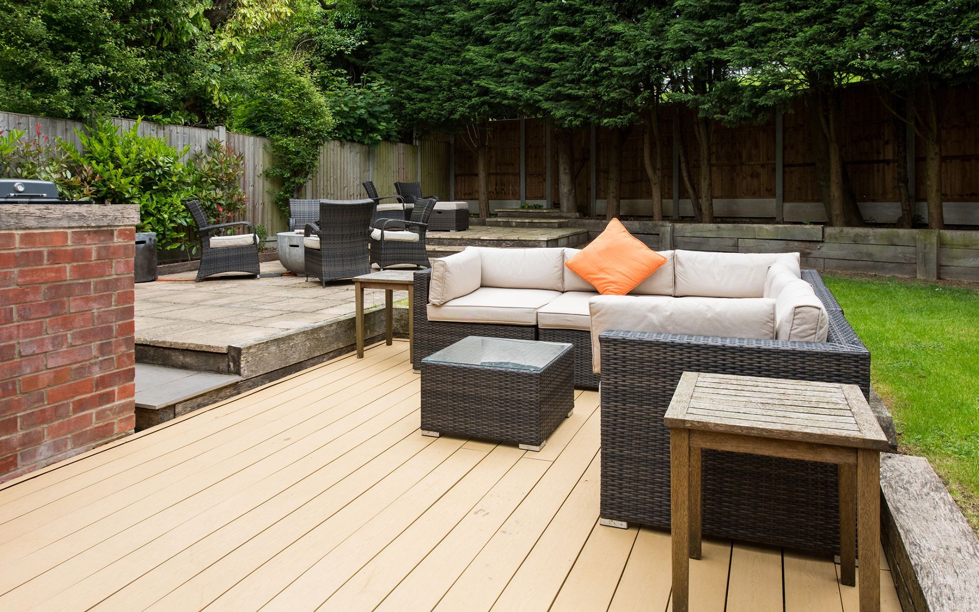 A wooden deck with a couch and chairs on it.