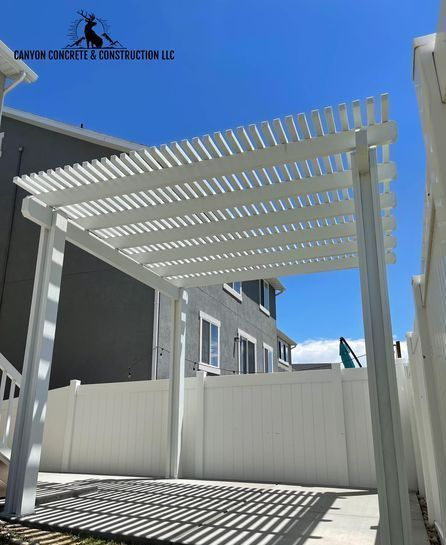 A white pergola with a blue sky in the background