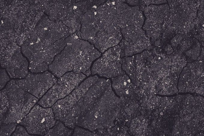 Cracks are beginning to show and low spots are forming on this asphalt driveway