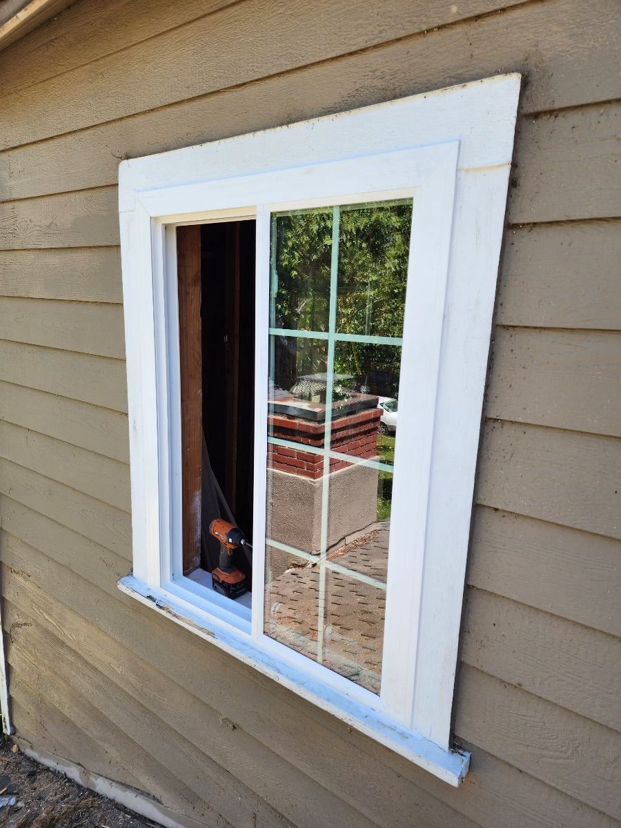 A window is being installed on the side of a house.