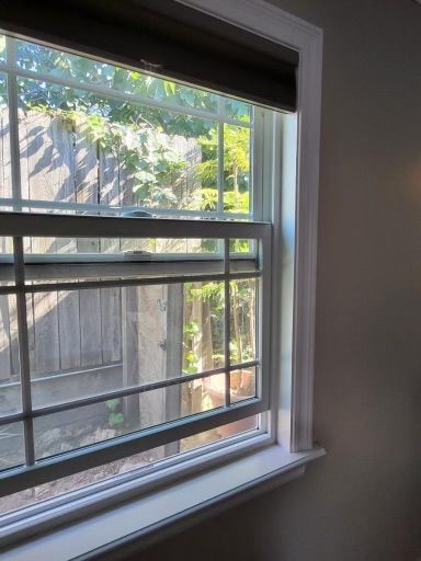 A window in a room with a fence in the background.