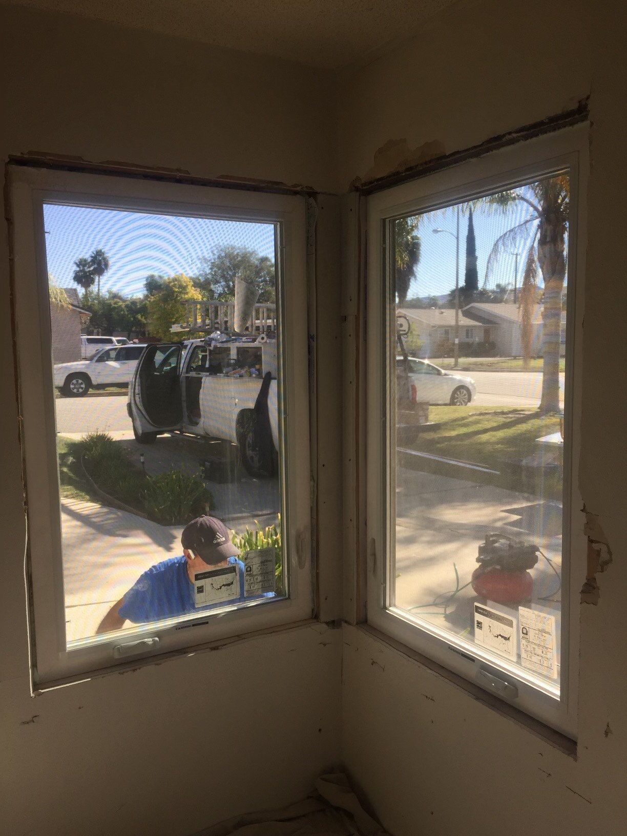 A man is working on a window in a room.