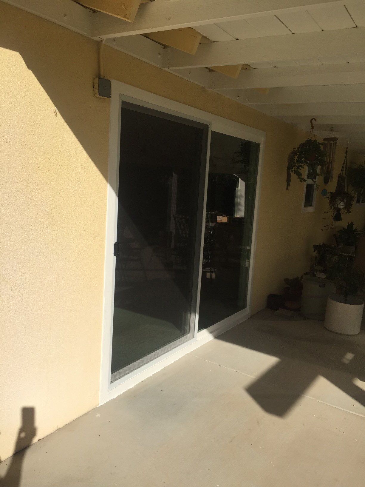 A patio with a sliding glass door and a white trim.