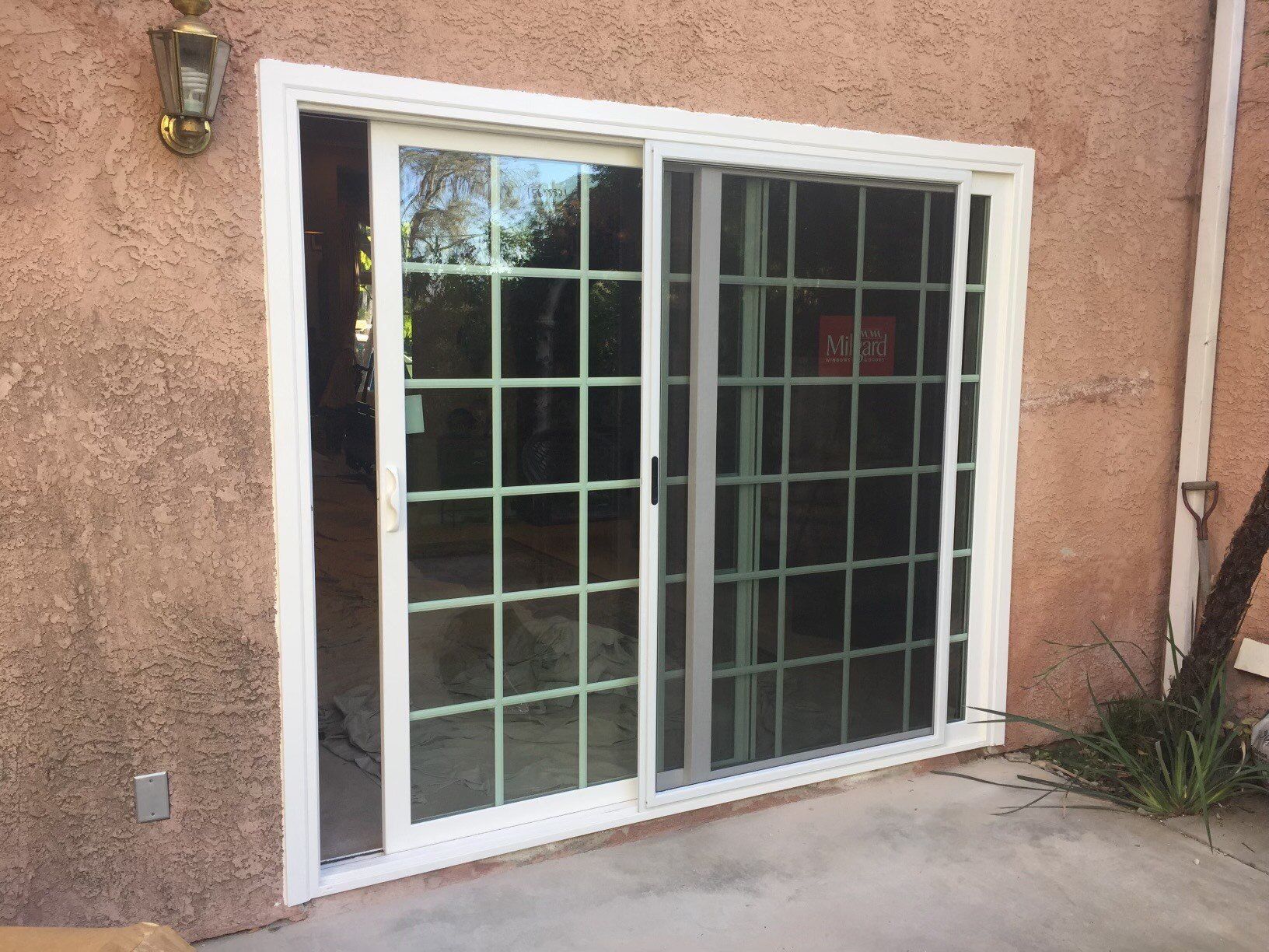 A white sliding glass door is open to a patio.