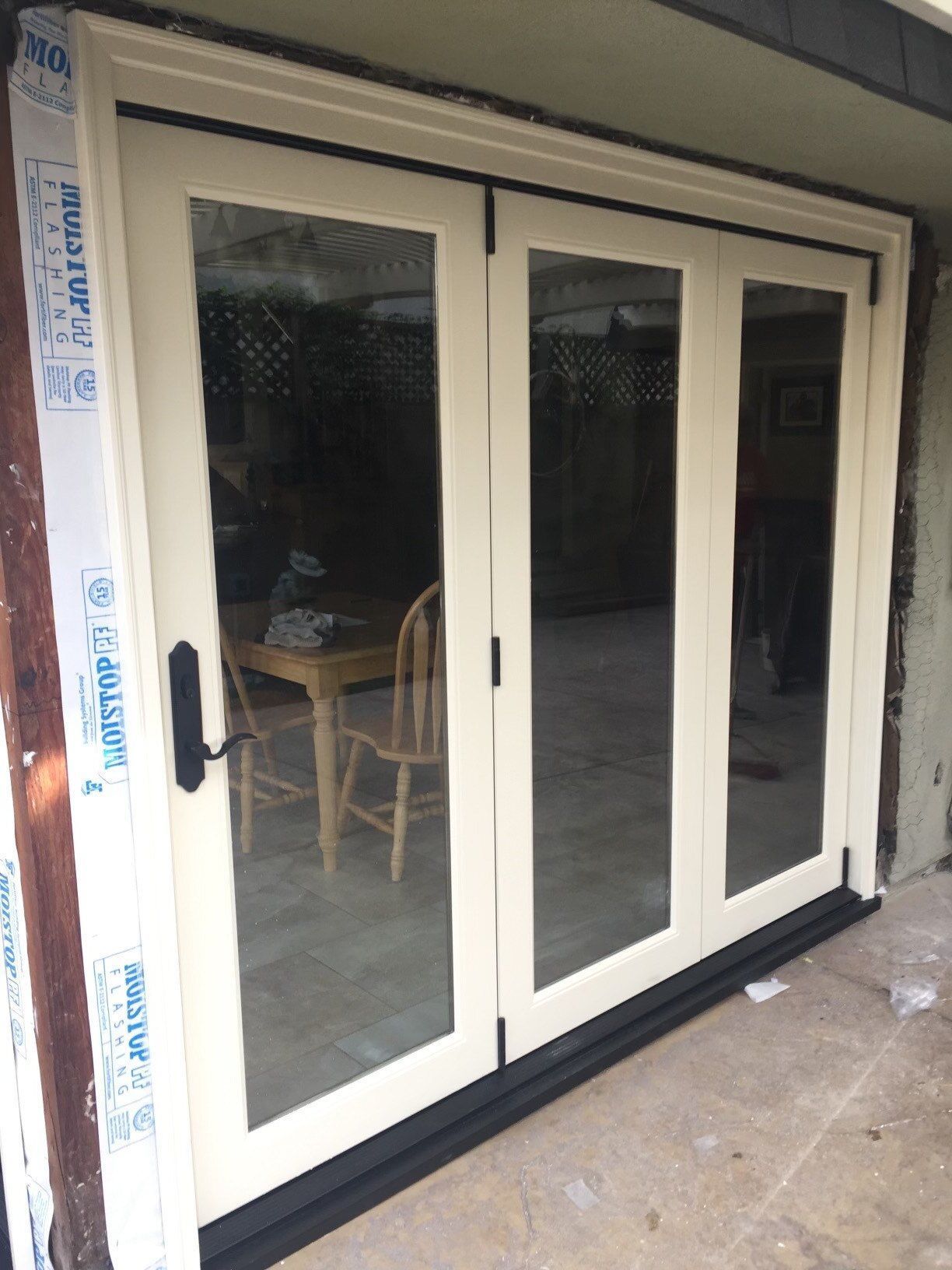 A white sliding glass door with a table and chairs behind it
