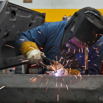 Rb Garage - A man wearing a welding mask is welding a piece of metal