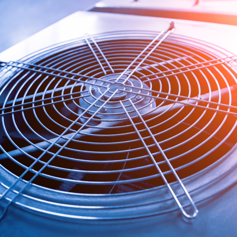 A close up of a fan with a grid around it.
