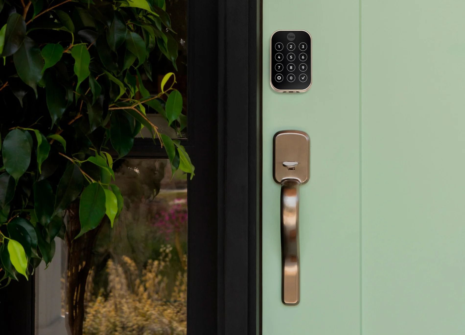 Exterior view of a Yale smart door lock equipped with a keypad on a green-coloured door. Exterior view of a Yale smart door lock equipped with a keypad on a green-coloured door.