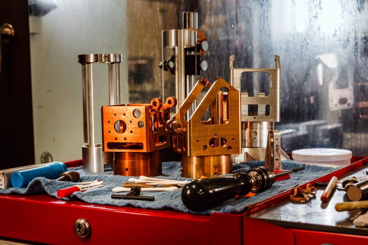 A bunch of metal parts are sitting on top of a red table.