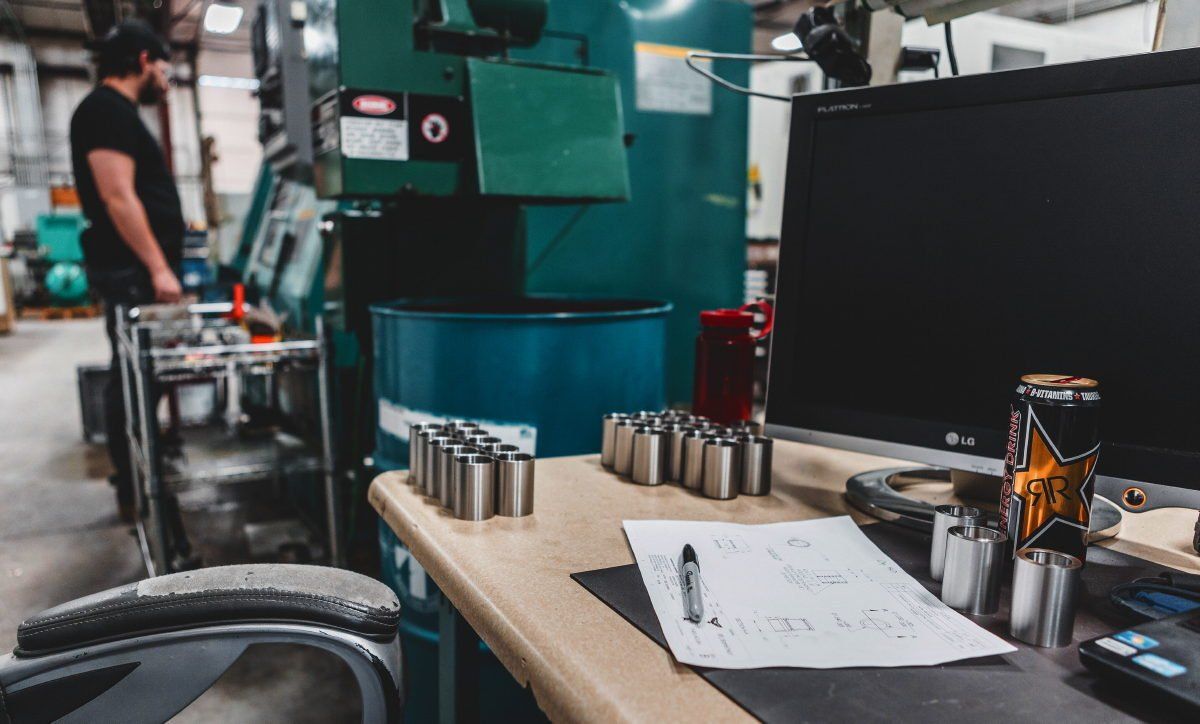 A man is standing in front of a machine in a factory.