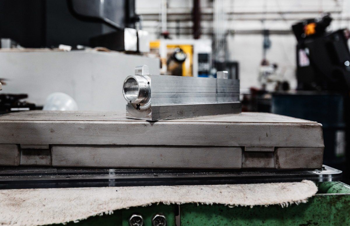 A piece of metal is sitting on top of a table in a factory.